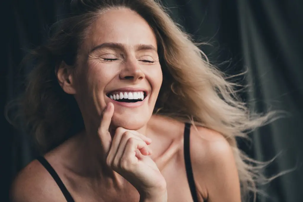 closeup of a blonde woman showing her flawless smile