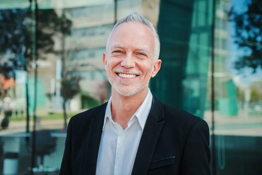 businessman smiling in front of office building, perfect new smile