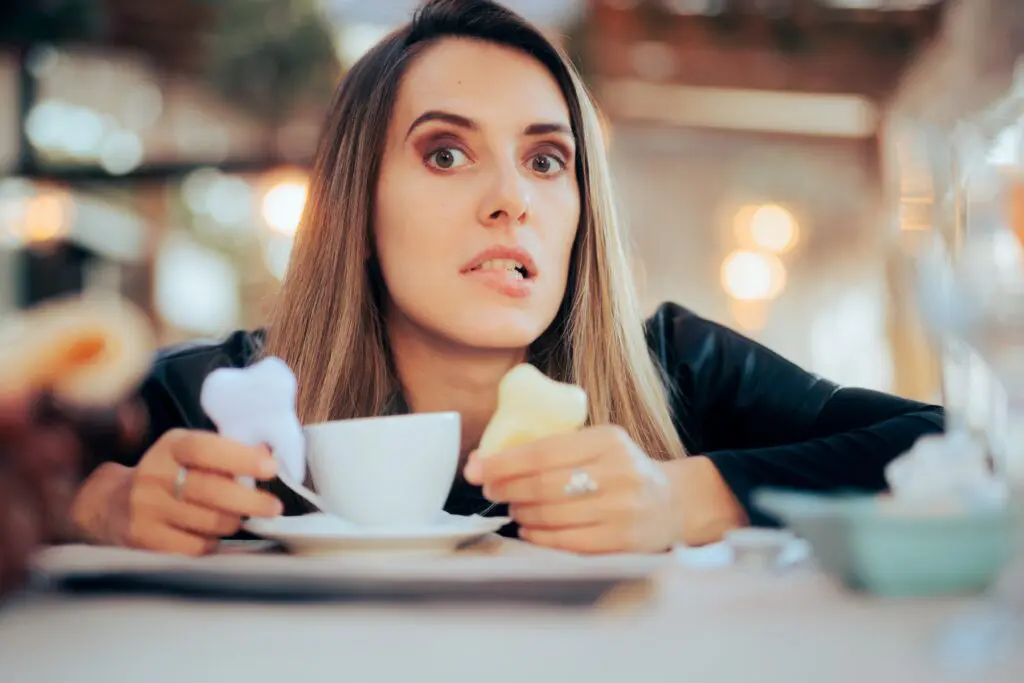 worried woman in a coffee shop, yellowing teeth