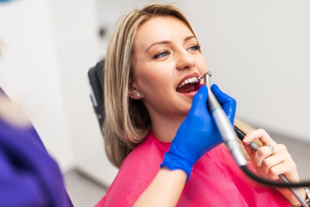 dentist polishing a female patients dental crown